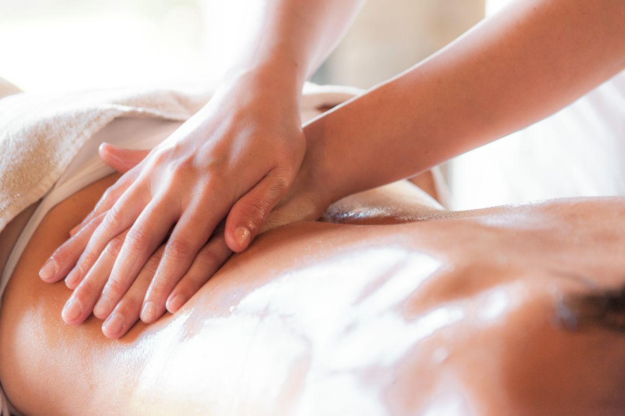 Close-up of therapist hands providing a relaxing massage with oil for wellness.
